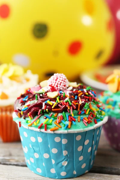 Deliciosos cupcakes de cumpleaños en la mesa sobre un fondo brillante — Foto de Stock