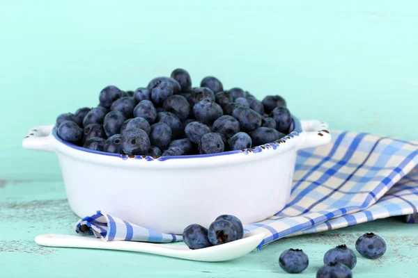 Bleuets mûrs savoureux dans un bol, sur une table en bois — Photo