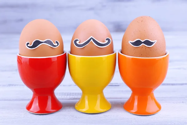 Яйца в стаканах для яиц на сером деревянном фоне — стоковое фото