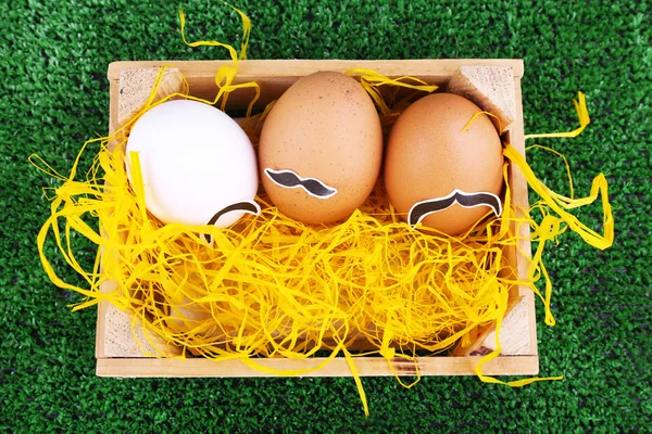 Huevos en caja de madera sobre fondo verde —  Fotos de Stock