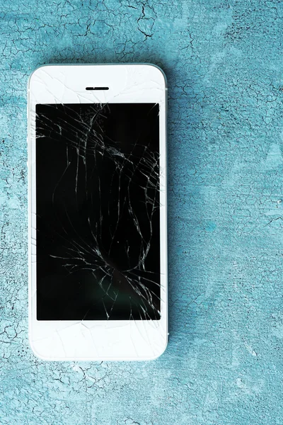 Modern mobiltelefon törött képernyővel fából készült háttérrel — Stock Fotó