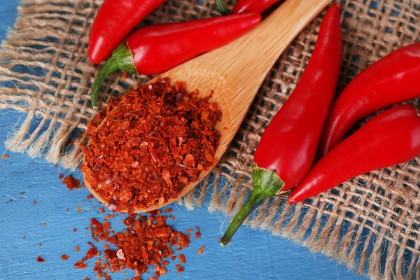 Milled red chili pepper in  spoon on wooden background — Stock Photo, Image