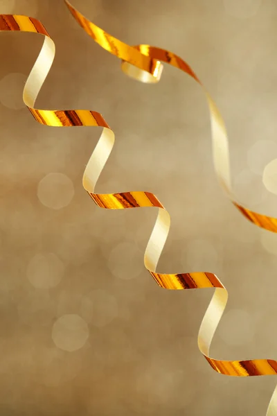 Serpentinenband auf goldenem, glänzenden Hintergrund — Stockfoto