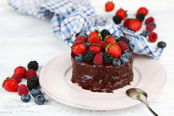 Smaczne ciasto czekoladowe z różnych owoców, na drewnianym stole — Zdjęcie stockowe