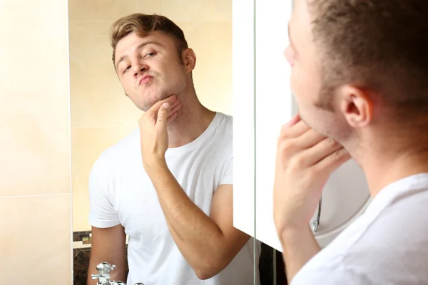Joven afeitándose la barba en el baño — Foto de Stock