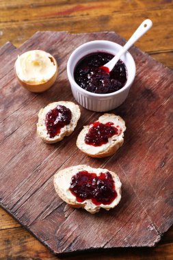 taze ekmek ile ev yapımı tereyağı ve blackcurrant jam ahşap arka plan üzerinde
