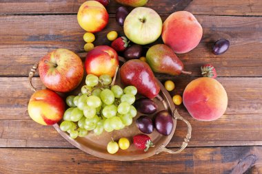 farklı meyveler ve meyve tepsi üzerinde ahşap masa yakın çekim