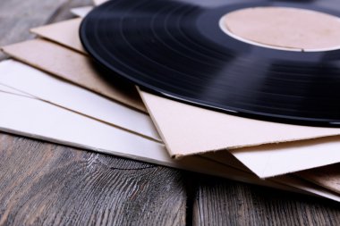 vinil kayıtları ve kağıt kapakları ahşap zemin üzerinde