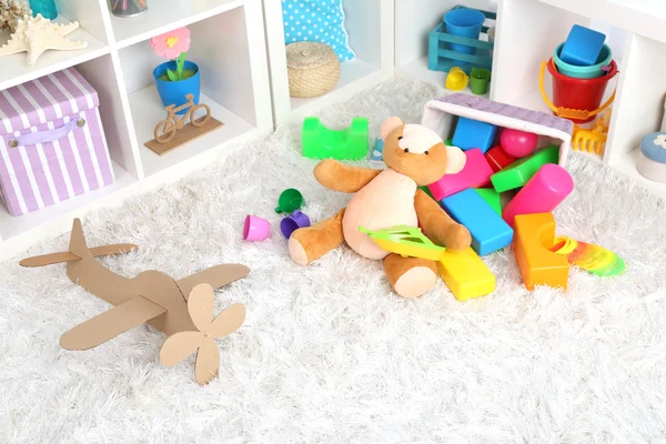 Juguetes coloridos en alfombra esponjosa en la habitación de los niños — Foto de Stock