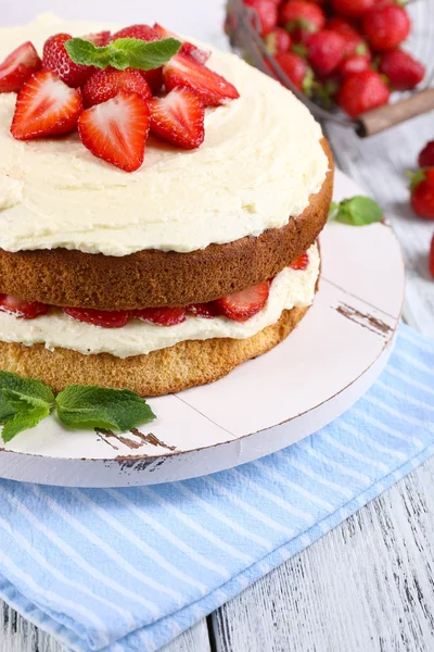 Delicious biscuit cake with strawberries on table close-up — Stock Photo, Image