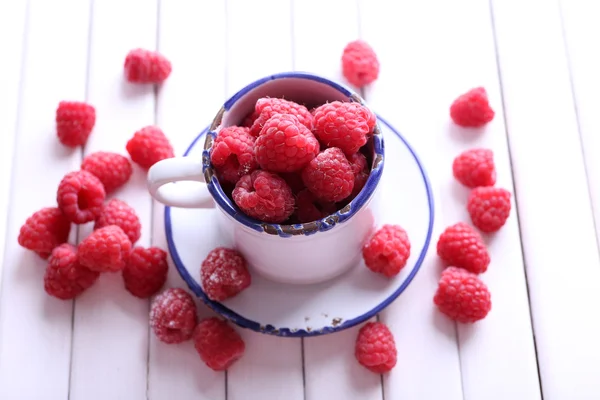 Reife süße Himbeeren im Becher auf dem Tisch in Großaufnahme — Stockfoto