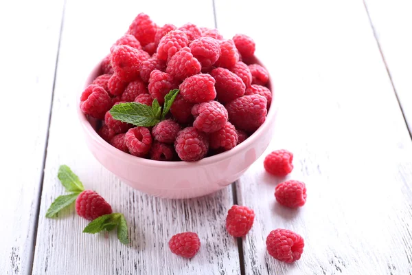 Ripe sweet raspberries in bowl on table close-up — Stock Photo, Image