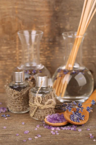 Bodegón Spa con aceite de lavanda y flores sobre mesa de madera —  Fotos de Stock