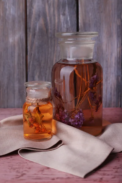 Botellas de tintura herbal en una mesa de madera frente a la pared de madera —  Fotos de Stock