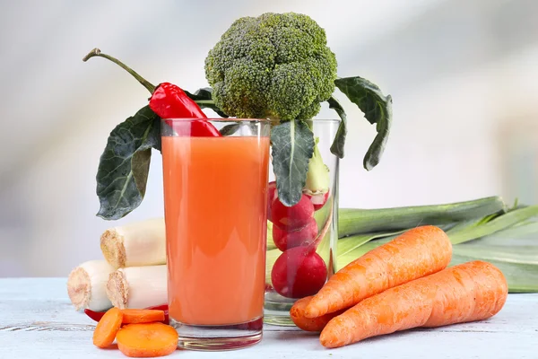 Verre de jus de carotte frais avec légumes sur table en bois — Photo