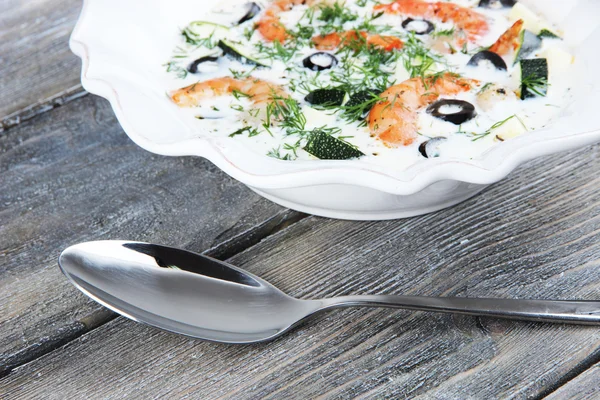 Fresh prawns with olives and avocado in sauce with spoon on wooden background — Stock Photo, Image