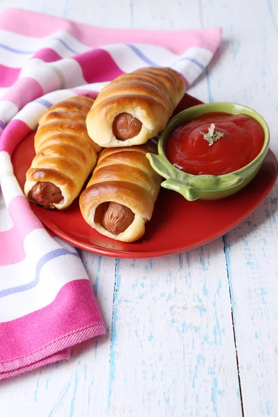 Baked sausage rolls on plate on table close-up — Stock Photo, Image