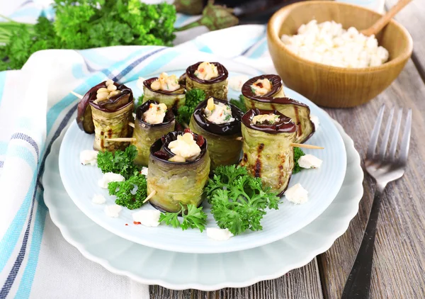 Gebakken aubergine met cottage kaas in een ronde plaat op houten achtergrond — Stockfoto