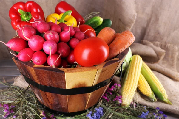 Grand panier rond en bois avec légumes sur fond de sac — Photo