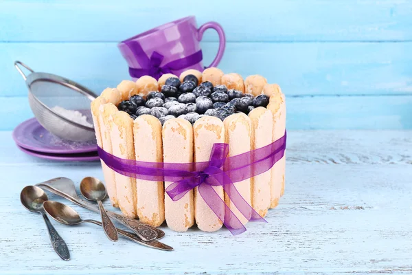 Tasty cake Charlotte with blueberries on blue wooden table — Stock Photo, Image