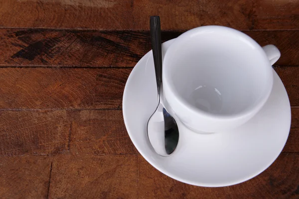 Empty cup with tea spoon on wooden background — Stock Photo, Image