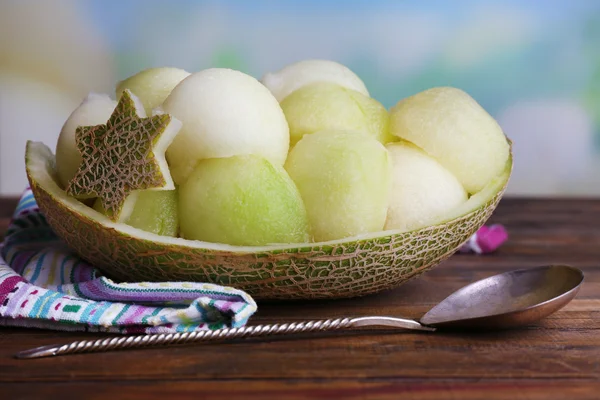 Melone in Melonenschale auf Serviette auf Holztisch auf natürlichem Hintergrund — Stockfoto