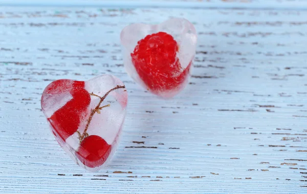 Eiswürfel mit roter Johannisbeere, auf Holzgrund — Stockfoto
