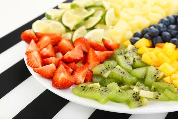 Frutas fatiadas no prato na mesa — Fotografia de Stock