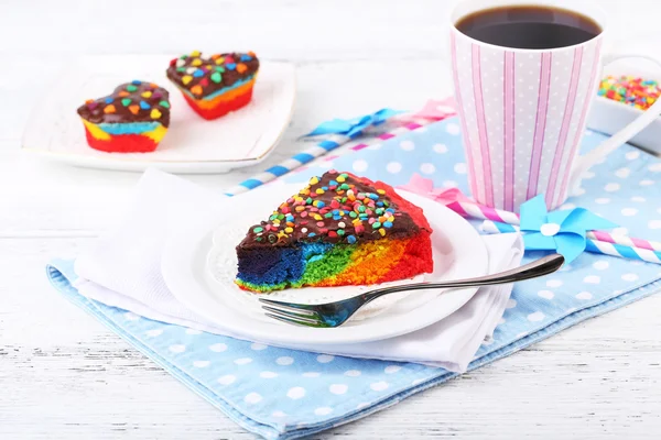 Deliziosa torta arcobaleno sul piatto, sul tavolo, su sfondo chiaro — Foto Stock