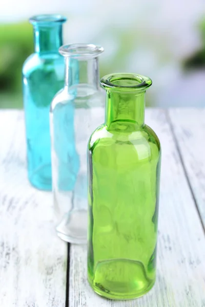 Empty glass bottles on table on bright background — Stock Photo, Image