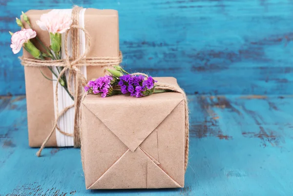 Belos presentes com flores, no velho fundo de madeira — Fotografia de Stock