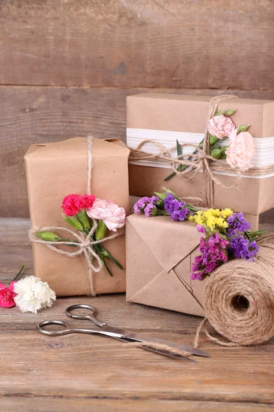 Piękne prezenty z kwiatów i liny ozdobne, na stare drewniane tła — Zdjęcie stockowe