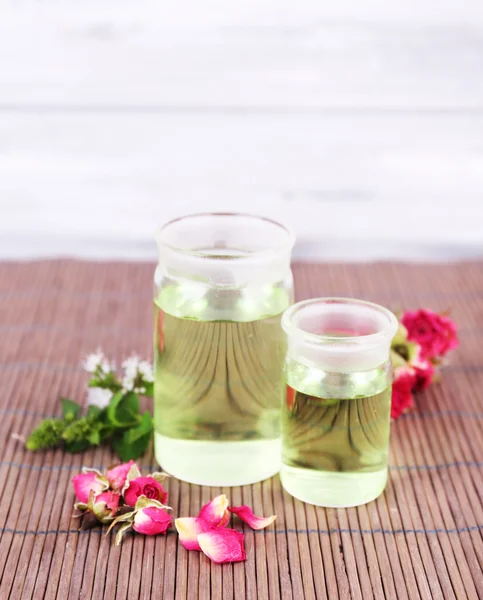 Essential oil with different medicine plants, on wooden background — Stock Photo, Image