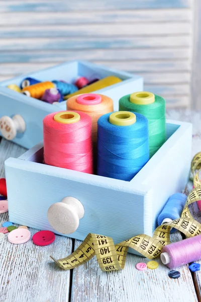 Sewing Accessories in wooden boxes on table on light blue background — Stock Photo, Image