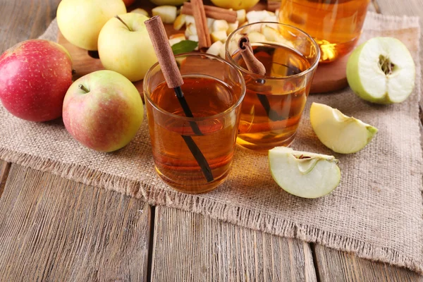 Bodegón con sidra de manzana y manzanas frescas sobre mesa de madera — Foto de Stock