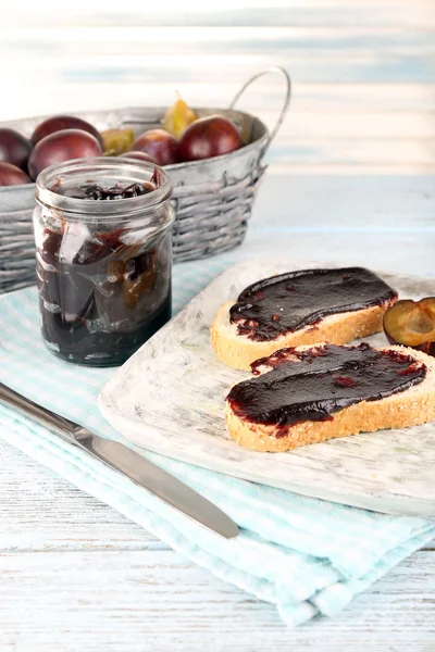 Brood met pruim jam en pruimen op houten tafel — Stockfoto