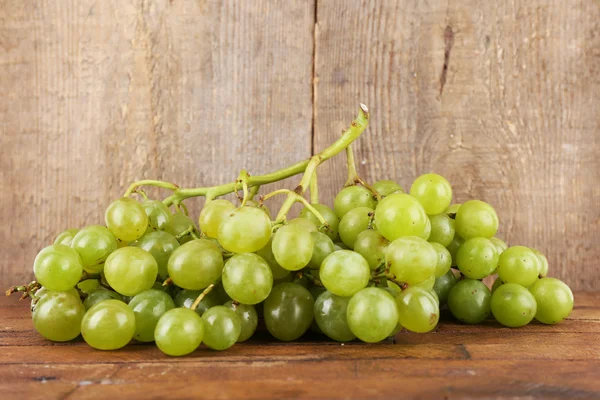 Groene druif op houten tafel op houten achtergrond — Stockfoto