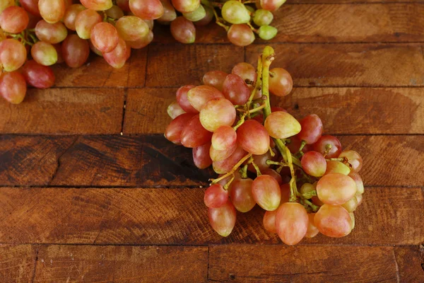 Розовый виноград на деревянном столе на деревянном фоне — стоковое фото