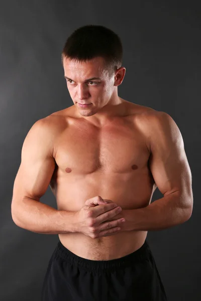 Handsome muscle young man on dark background — Stock Photo, Image