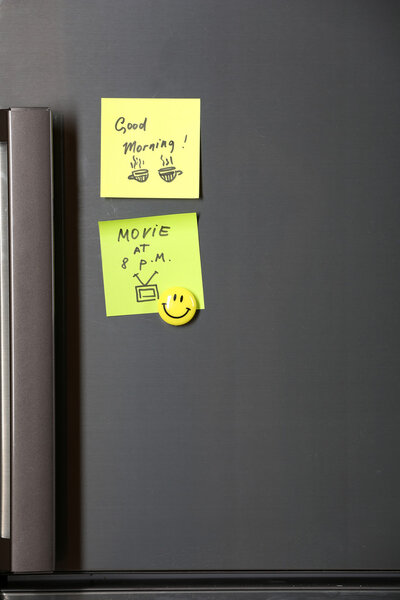 Note on piece of paper on refrigerator closeup