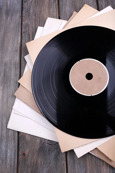 Registros de vinilo y cubiertas de papel sobre fondo de madera — Foto de Stock