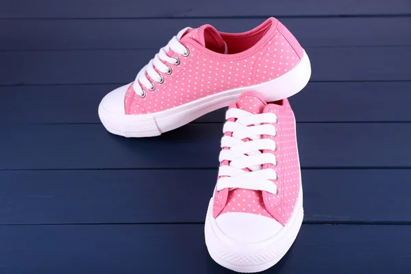 Pink trainers on dark blue wooden background — Stock Photo, Image