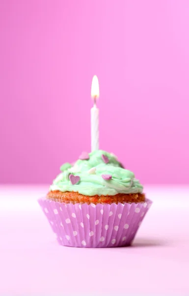 ピンク色の背景上のテーブルにおいしい誕生日カップケーキ — ストック写真