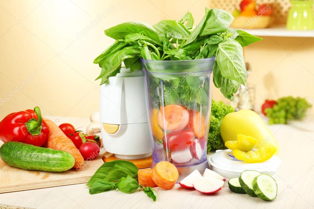Blender with fresh vegetables on kitchen table