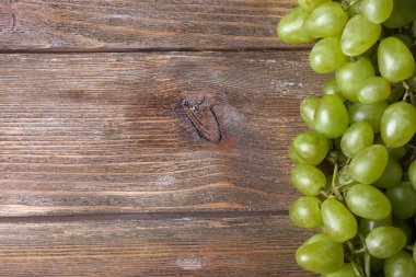 kahverengi ahşap zemin üzerinde olgunlaşmış üzümler demet