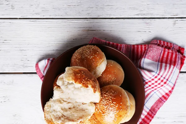 Lekkere broodjes met sesame op plaat, op een houten achtergrond kleur — Stockfoto