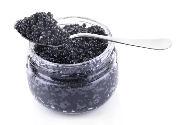 Glass jar and spoon of black caviar isolated on white — Stock Photo, Image