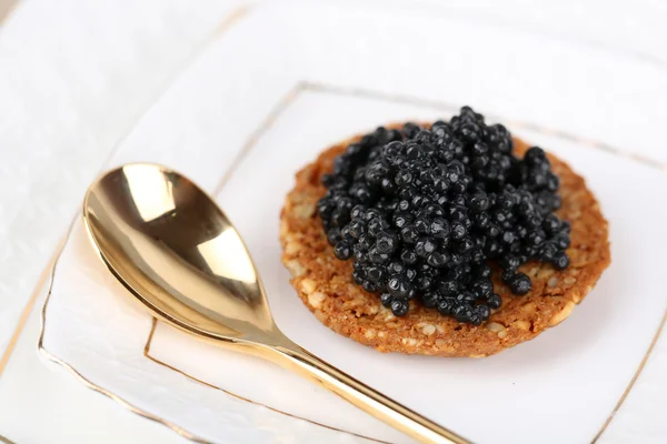 Caviar preto no pão crocante na placa closeup — Fotografia de Stock