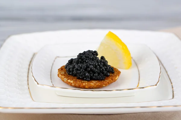 Caviar preto no pão crocante na placa — Fotografia de Stock
