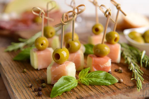 Delicious melon with prosciutto on table close-up — Stock Photo, Image